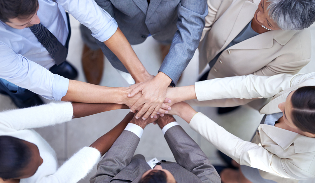 Shot of a group of coworkers with their hands in a huddle